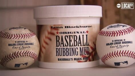 Baseball rubbing mud in between two baseballs.