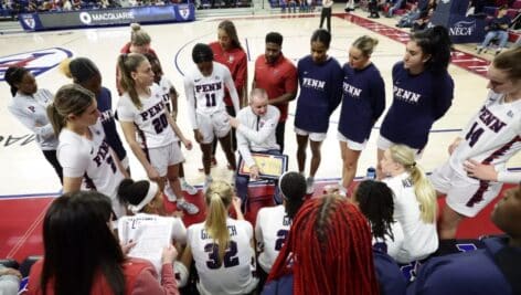 Penn women's basketball team in a huddle.