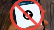 Man using TikTok on smartphone with red forbidden circle superimposed.