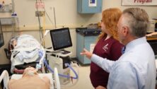 respiratory care teacher instructs student in a simulation lab