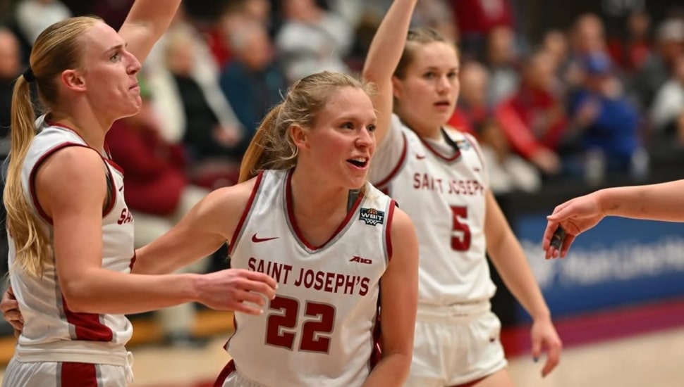 Chloe Welch celebrates with teammates on the basketball court.