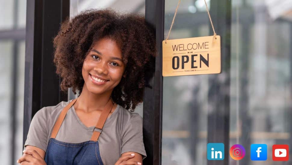 Young black woman standing in the doorway of her store.