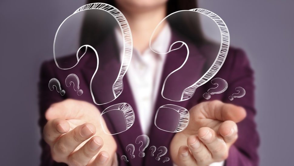 Businesswoman holding question marks in her hands.