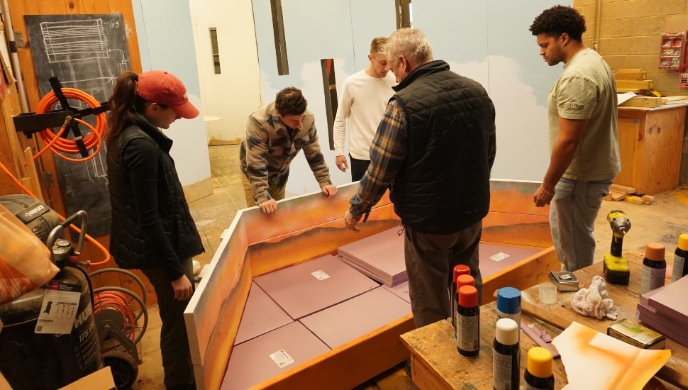 Horticulture students work with college professor on flower show exhibit.