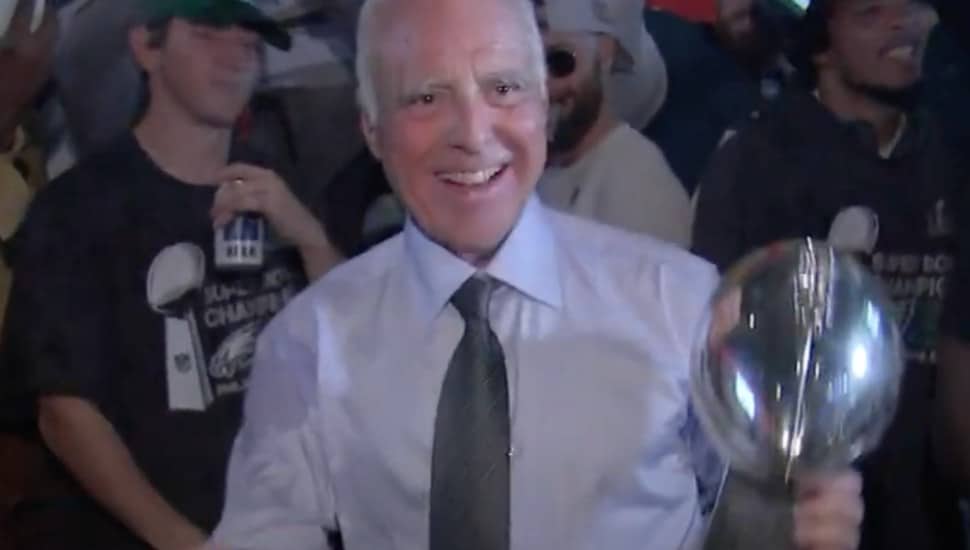 Jeffrey Lurie holds the Lombardi trophy in the Eagles locker room.
