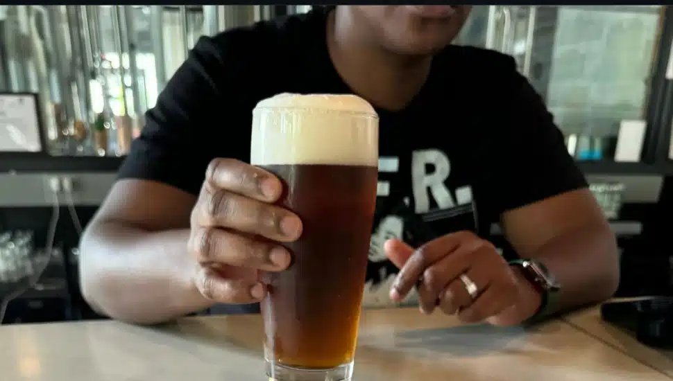 A person holding a case of Mexican Dark Lager beer.