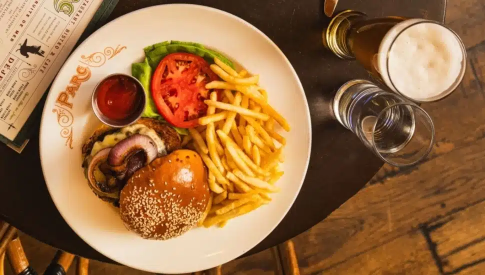 A burger and fries with drinks.