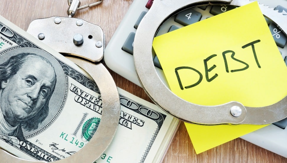 Debt in handcuffs and money for payment. Problems with loans.