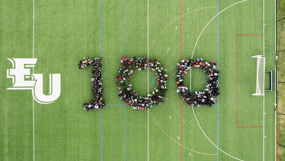 Aerial view of college students forming the number 100.