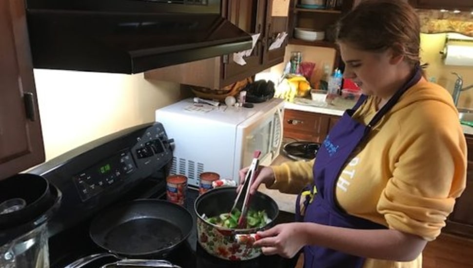 A woman cooking on a stove.