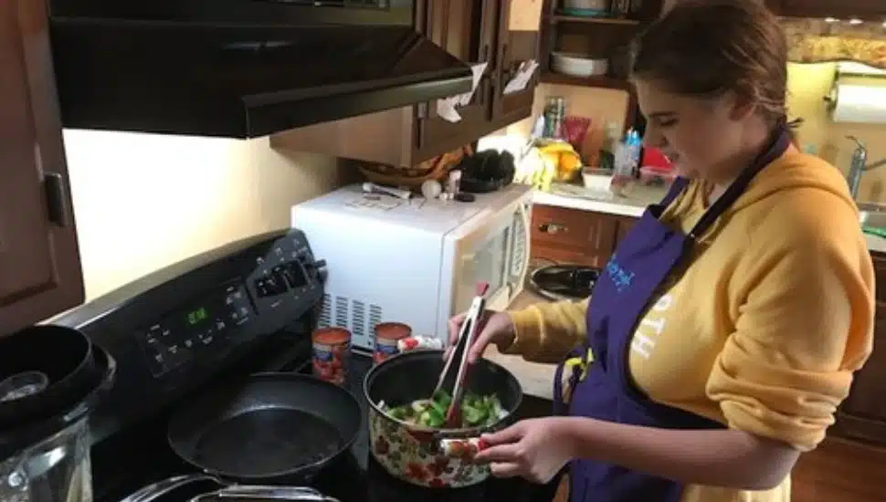 A woman cooking on a stove.