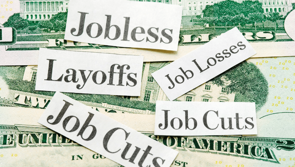 Federal Layoffs lables over a pile of money