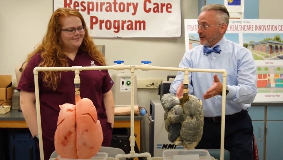 College professor teaches student about respiratory care.