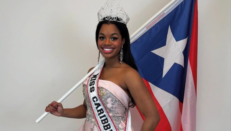 Jacqueline Means with crown, "Miss Caribbean US" sash, and a Puerto Rican flag.