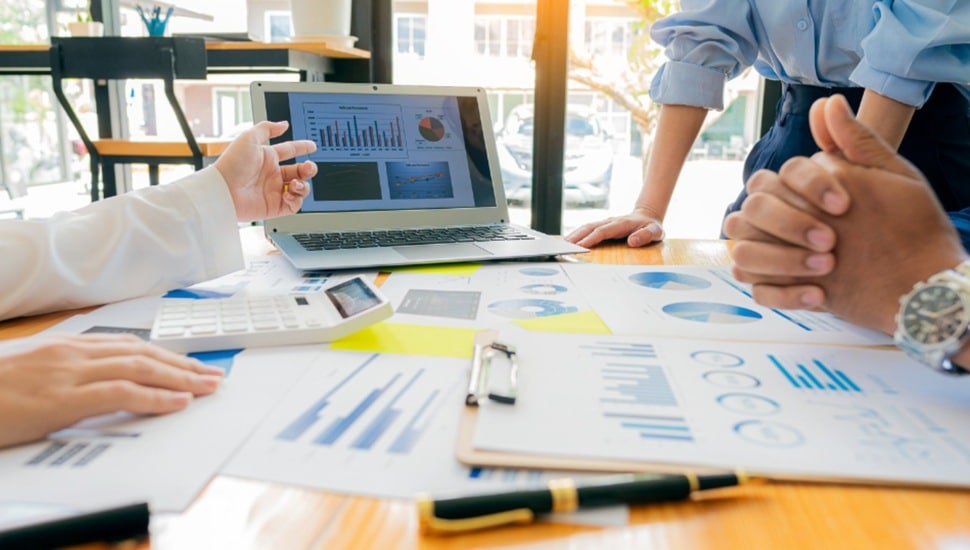Businesspeople work at a conference room table.