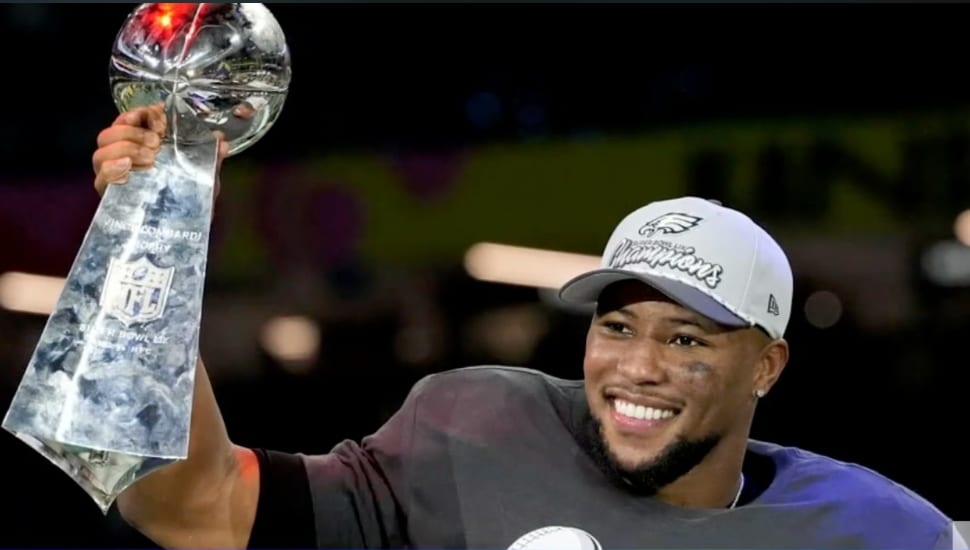 Saquon Barkley holding trophy after Super Bowl win.