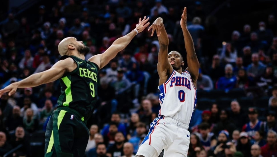 Tyrese Maxey shooting a basketball with Derrick White defending.