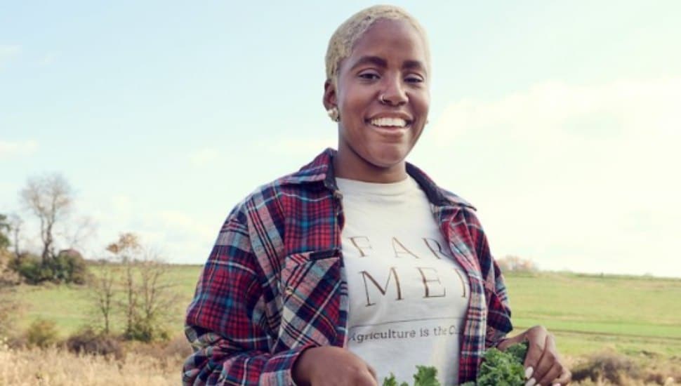 Christa Barfield, aka FarmerJawn, outside on farmland.