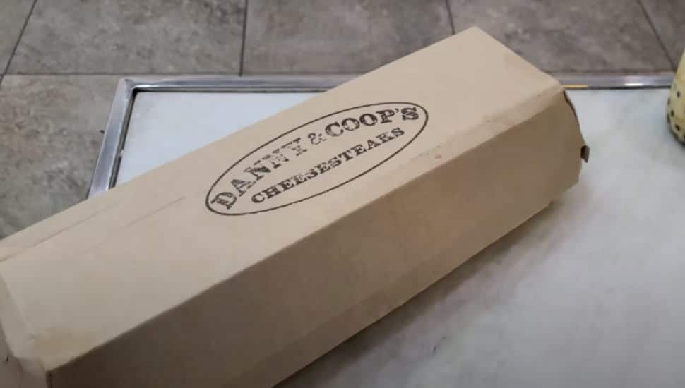 A brown box containing a Danny and Coop's cheesesteaks.