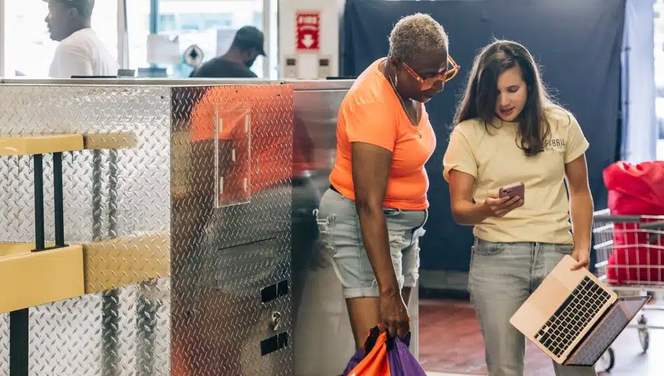 Two women at a laundromat.