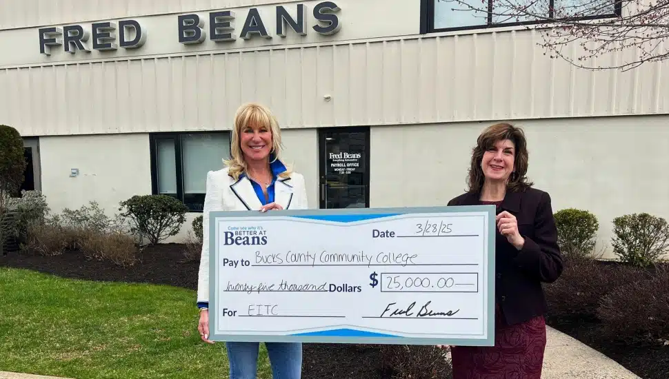 Fred Beans representative and Bucks County Community College representative holding $250,000 check.