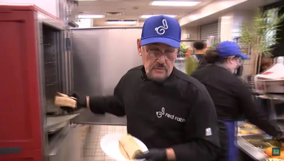 Javier Ramirez serving food in high school cafeteria.