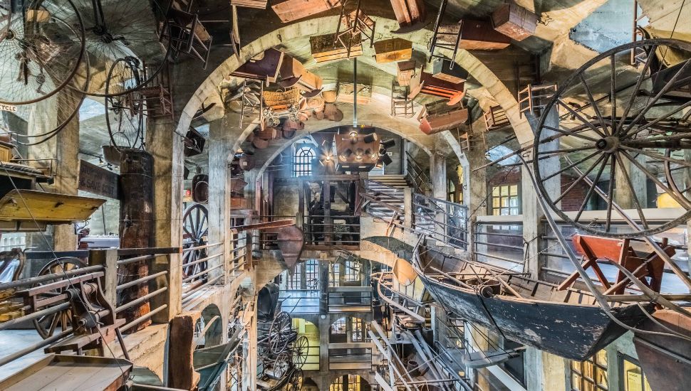 The interior exhibit area of the Mercer Museum covered in farm equipment and other historical items.