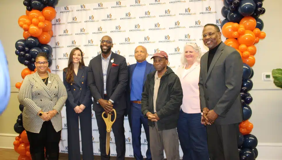 Staff, partners, and clients of the newly-opened Kingsessing Heals Community Resilience Center after ribbon cutting, with balloons in the background.