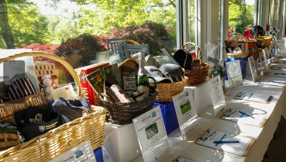 A table of raffle baskets filled with prizes at PSGV's 2024 Annual Golf Outing.