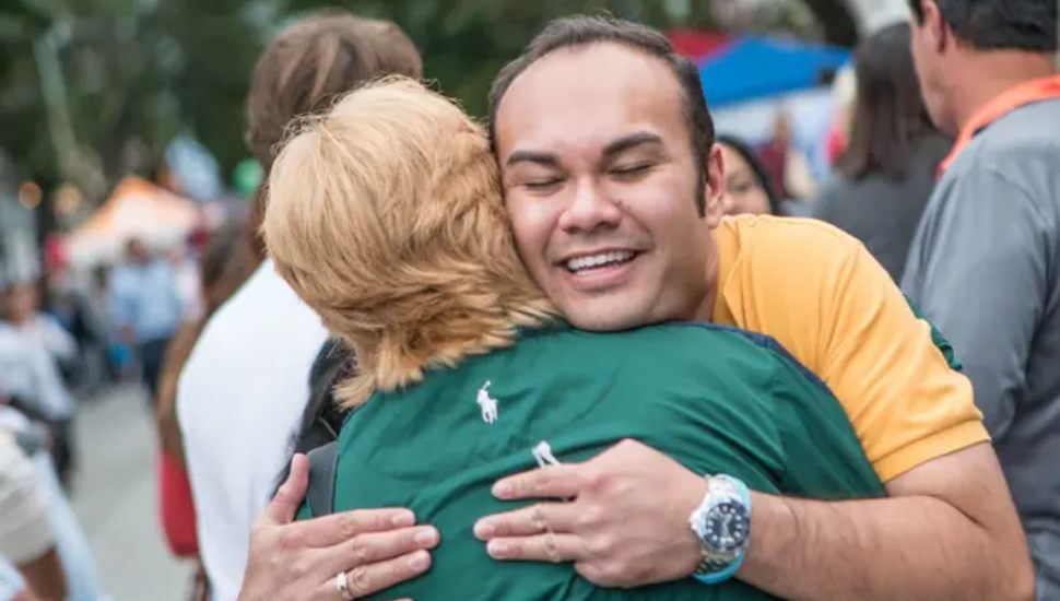Peter Urscheler hugs a woman in green shirt.