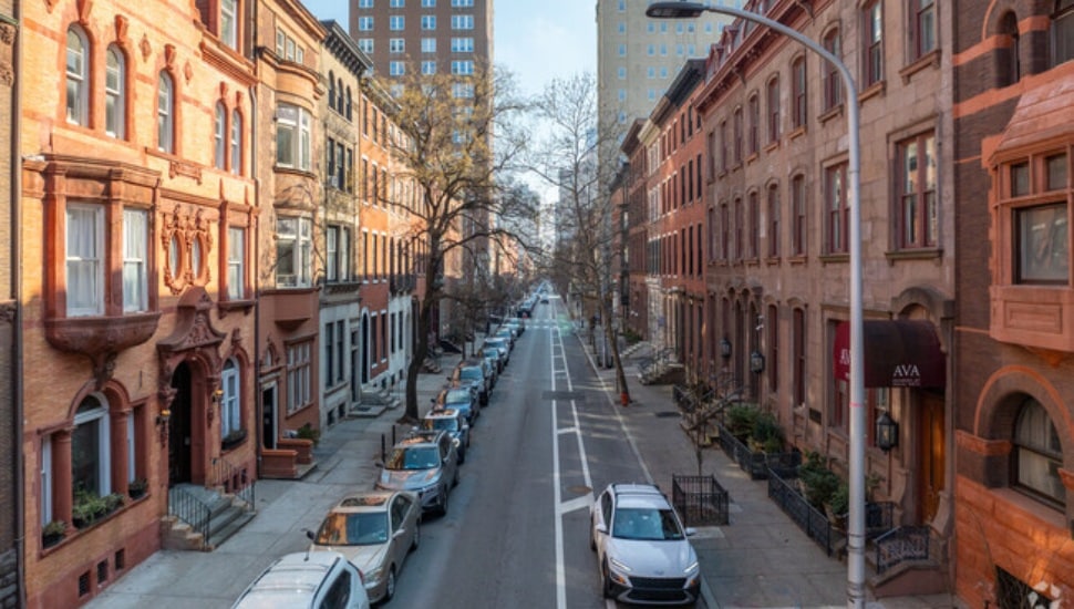 A shot of a Center City Philadelphia street with brownstones and cars.