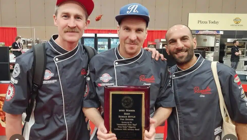 David Lubrano (middle) holds plaque alongside two team members.