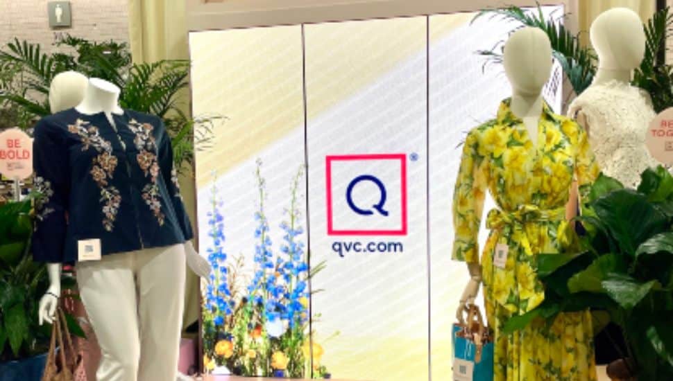 QVC stage with screen i n background and mannequins on either side.