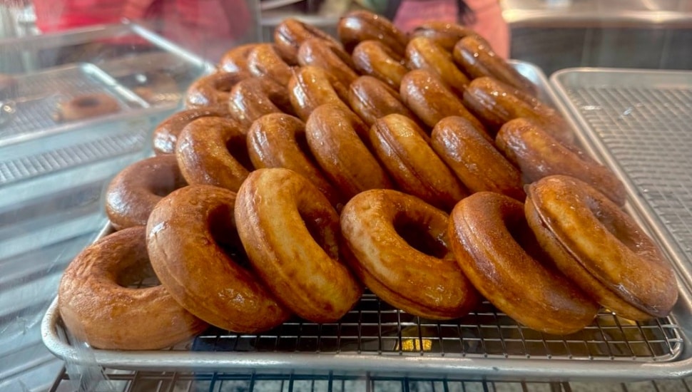 More than two dozen baked pancake donuts.