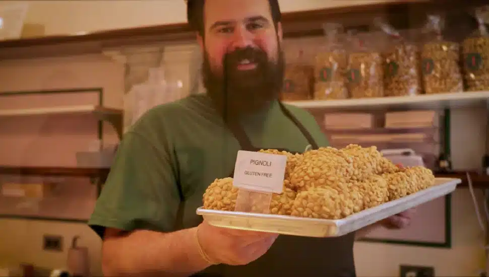 A.J. Sarno smiling while holding a tray of pignoli.