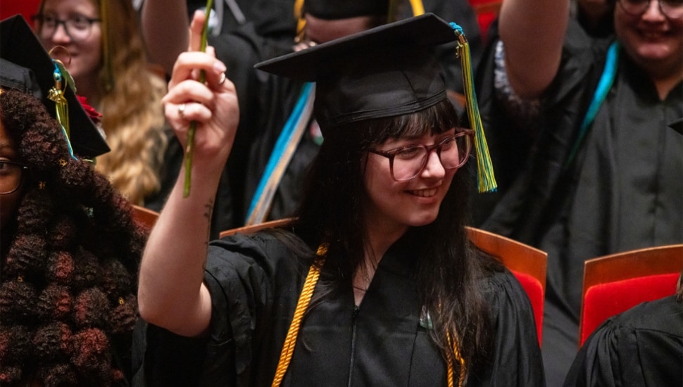 Young woman with a cap and gown at Moore College of Art & Design's graduation.