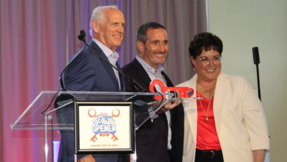 Howie Roseman holds award alongside Dan Hilferty and Kathryn Ott Lovell.