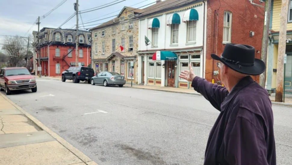 Mayor John Hagan gestures down a Parkesburg street.