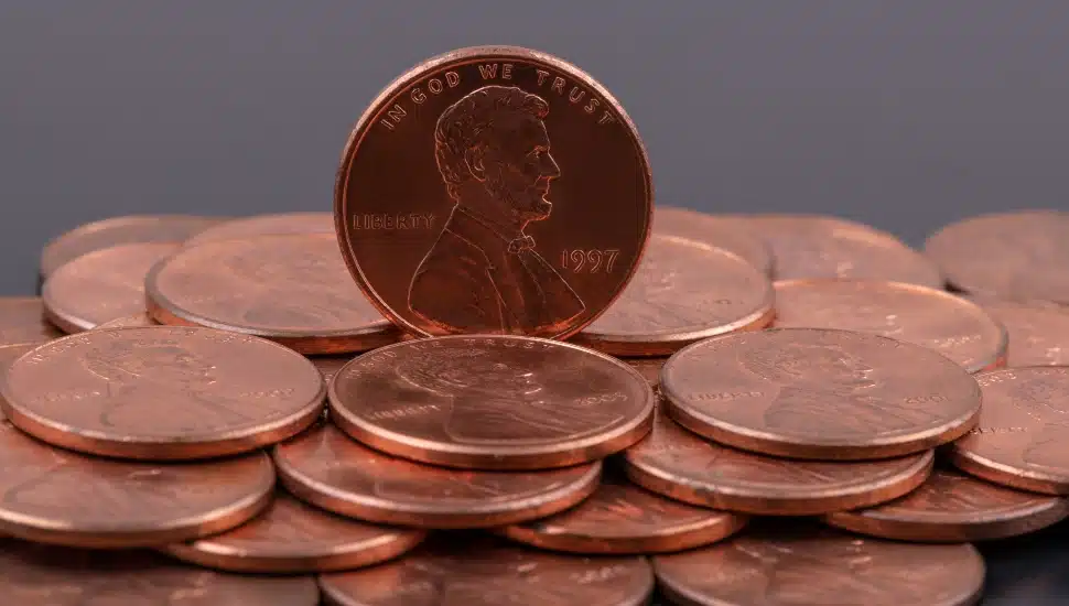 Coins in denominations of 1 American cent with a portrait of Abraham Lincoln on a gray background.