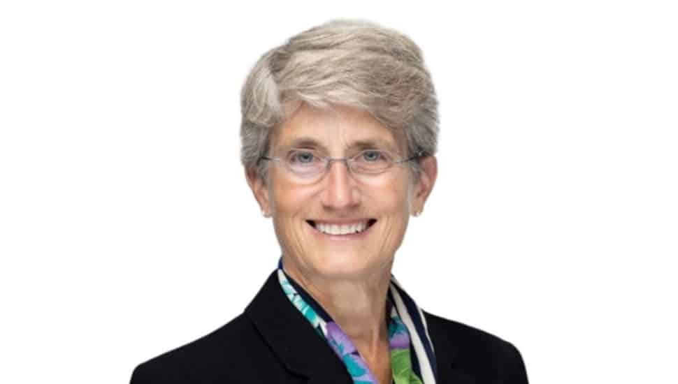 Headshot of older female banking executive with short gray and glasses.