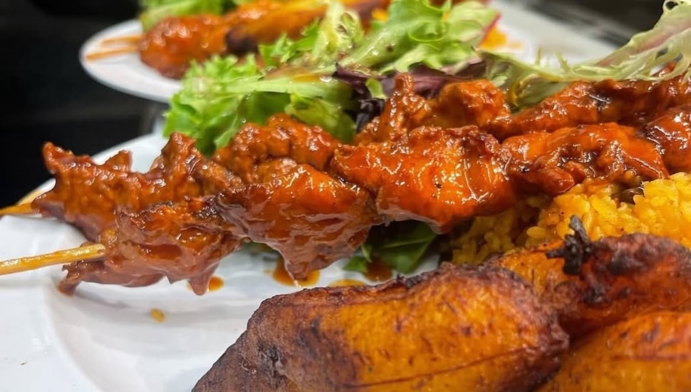 A plate from Casa Borinqueña with plantains, salad, and vegan chicken pinchos.