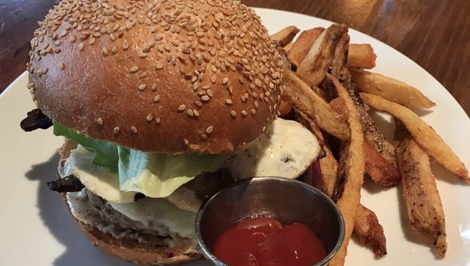 Hygge burger with fries and container of ketchup.