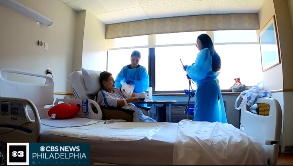 Two students helping a patient inside a room at Jefferson.