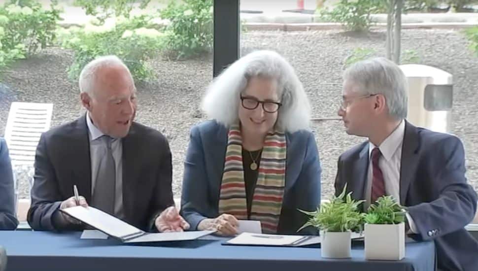 Jeffrey Lurie signs papers at the Lurie Autism Institute dedication.