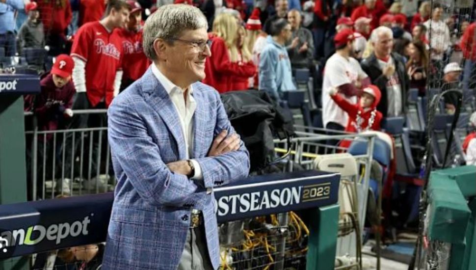 John Middleton stands with arms folded outside of the Phillies dugout.
