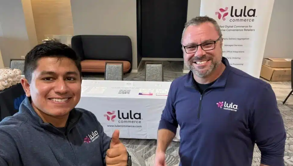 Lula Commerce team at a conference with a "Lula Commerce" backdrop and table cloth.
