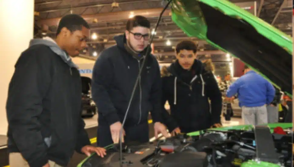 Students learning how to work on cars.