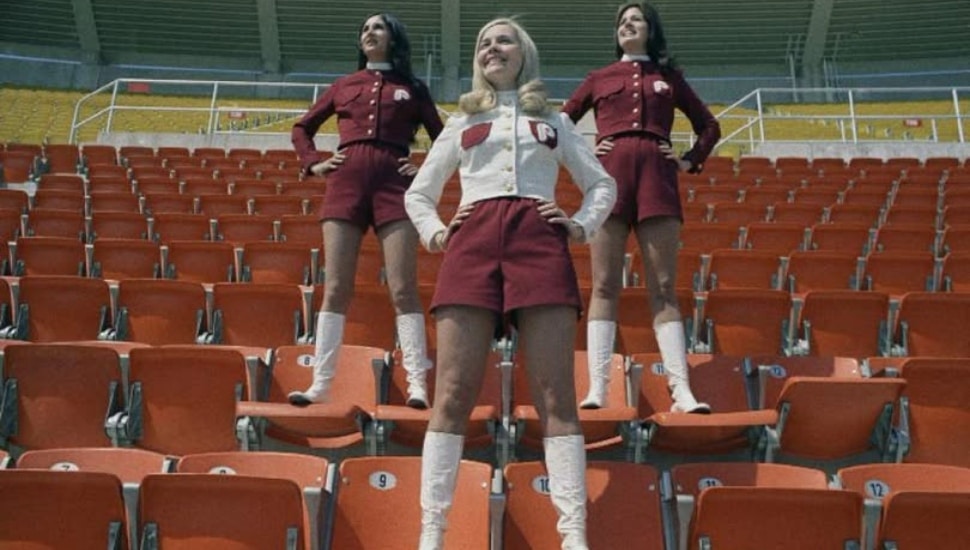 Three women who were part of the Phillies' Hot Pants Patrol standing on bleachers.
