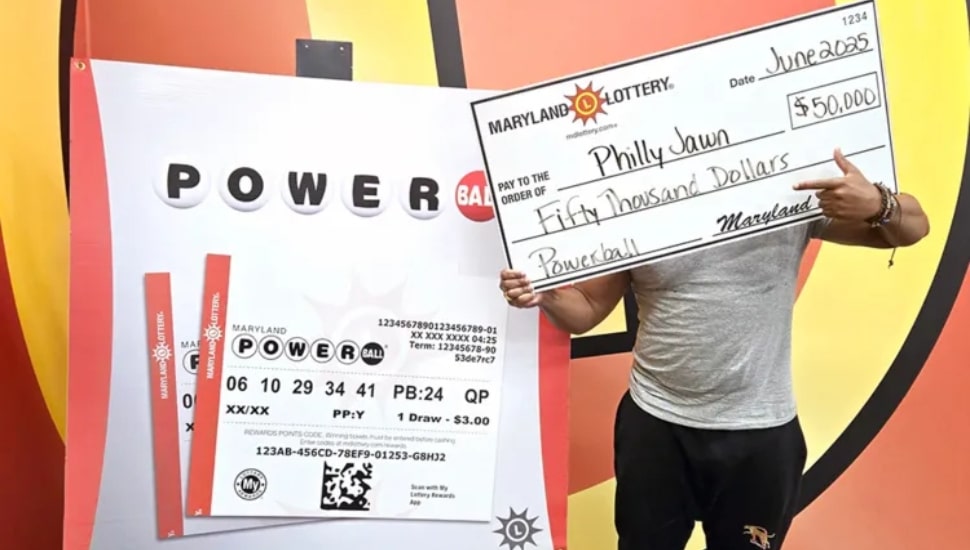 A man holding a $50,000 check in front of his face with a Powerball ticket in the background.