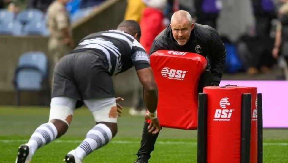 Richie Gray holding a tackle bag with a rugby player going towards it.